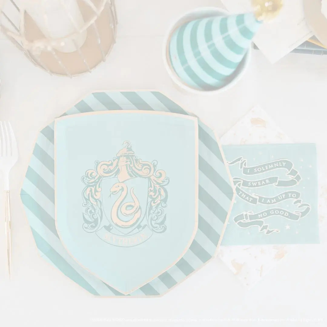 Faded overhead view of Harry Potter Slytherin shield plate and napkin on a green striped charger plate