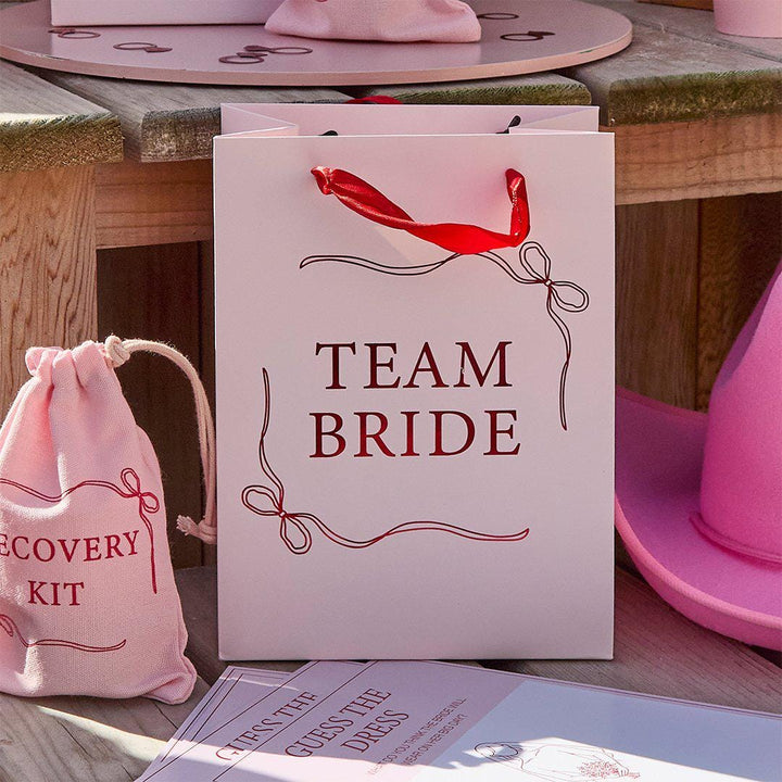 Team Bride Party Bags - Pink & Red She’s Tying The Knot Hen Do Gifts - Coquette Hen Party Gift Bags with Red Satin Handles - Pack of 5 - Jolie Fete UK