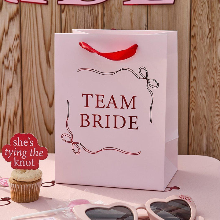 Team Bride Party Bags - Pink & Red She’s Tying The Knot Hen Do Gifts - Coquette Hen Party Gift Bags with Red Satin Handles - Pack of 5 - Jolie Fete UK