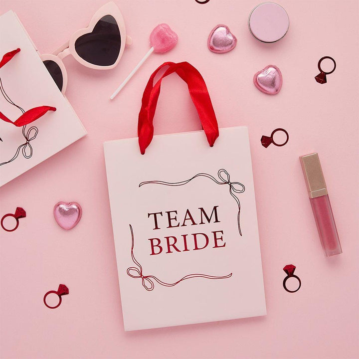 Team Bride Party Bags - Pink & Red She’s Tying The Knot Hen Do Gifts - Coquette Hen Party Gift Bags with Red Satin Handles - Pack of 5 - Jolie Fete UK