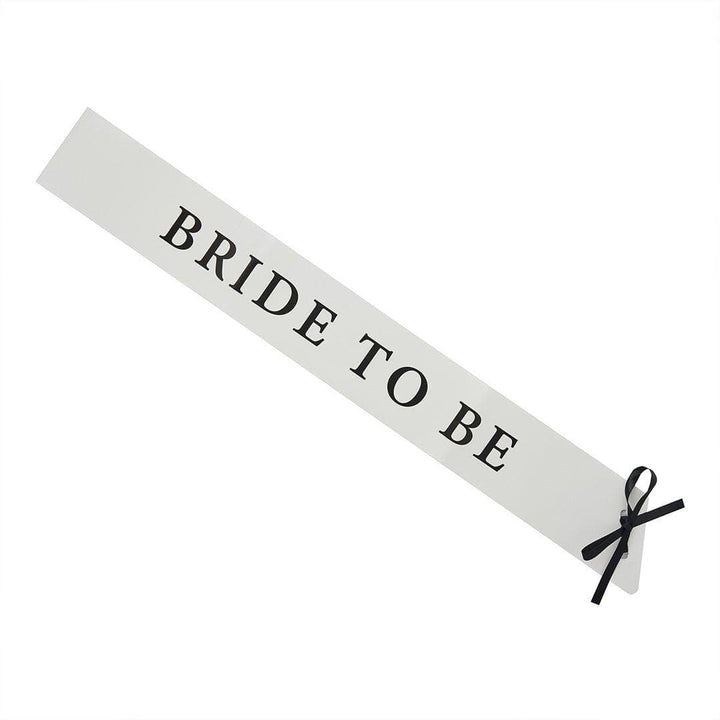 White Bride To Be Paper Sash - She’s Tying The Knot Hen Party Accessory - Coquette Bridal Shower Sash with Black Satin Ribbon - Hen Do Sash - Jolie Fete UK